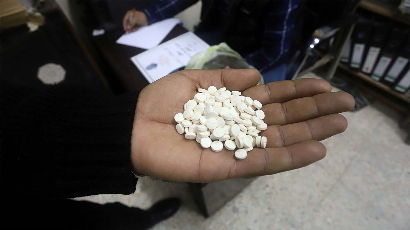 A police officer shows drug pills at a police station in Basra, Iraq 