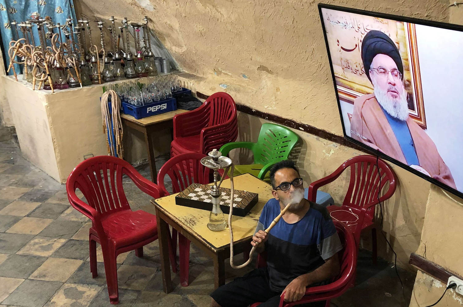 لبناني في مقهى يستمع لمقابلة نصرالله