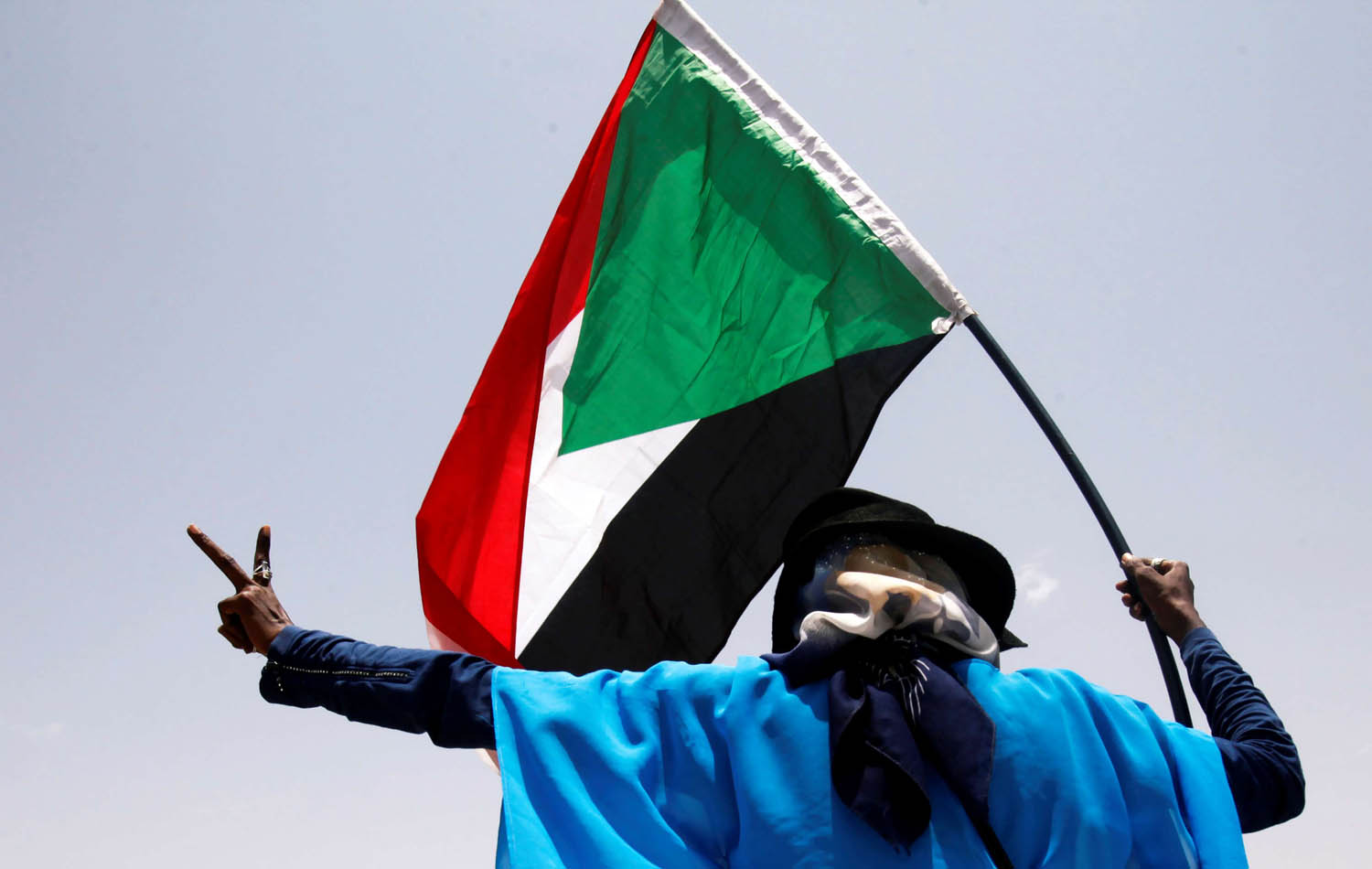 متظاهر يرفع شارة النصر في الخرطوم
