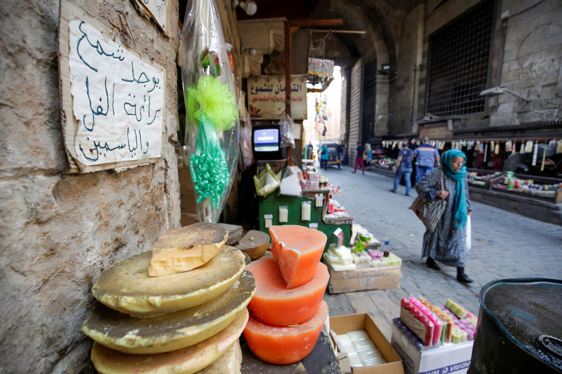 Egyptians walk in front of shops selling candles at Bab El Khalq street at al-Ghouria in old Islamic Cairo