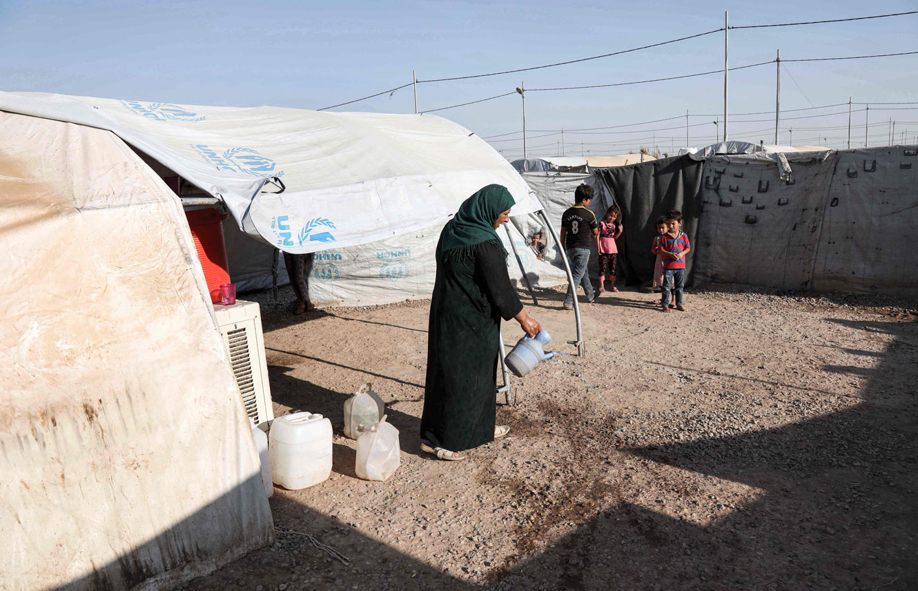  Iraqi family displaced from Mosul stands outside a tent