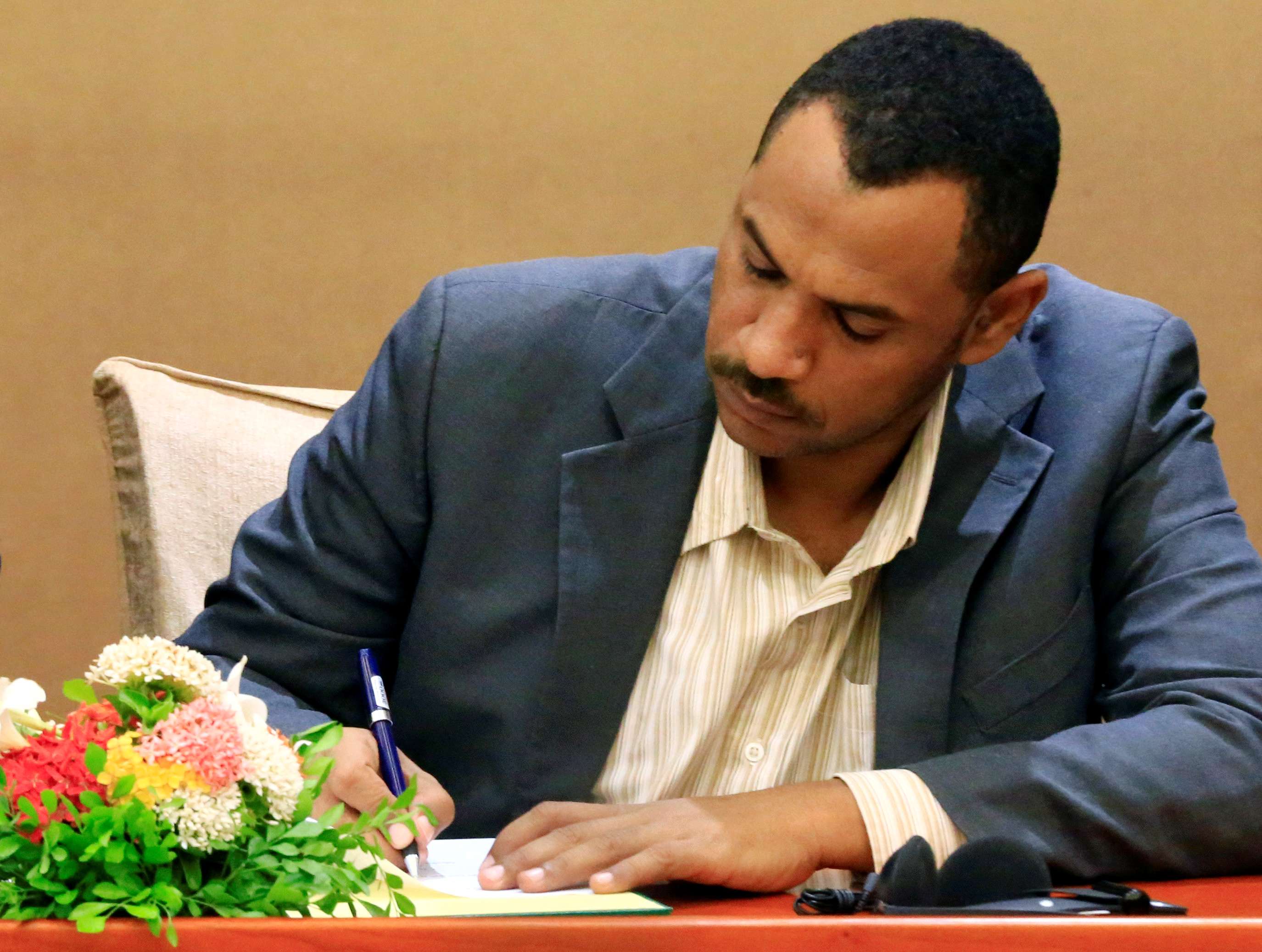Sudanese leader of the protest movement Ahmad al-Rabiah signs a constitutional declaration in Khartoum