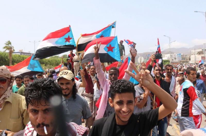 Yemeni demonstrators wave flags of former South Yemen as they march in Yemen’s second city of Aden