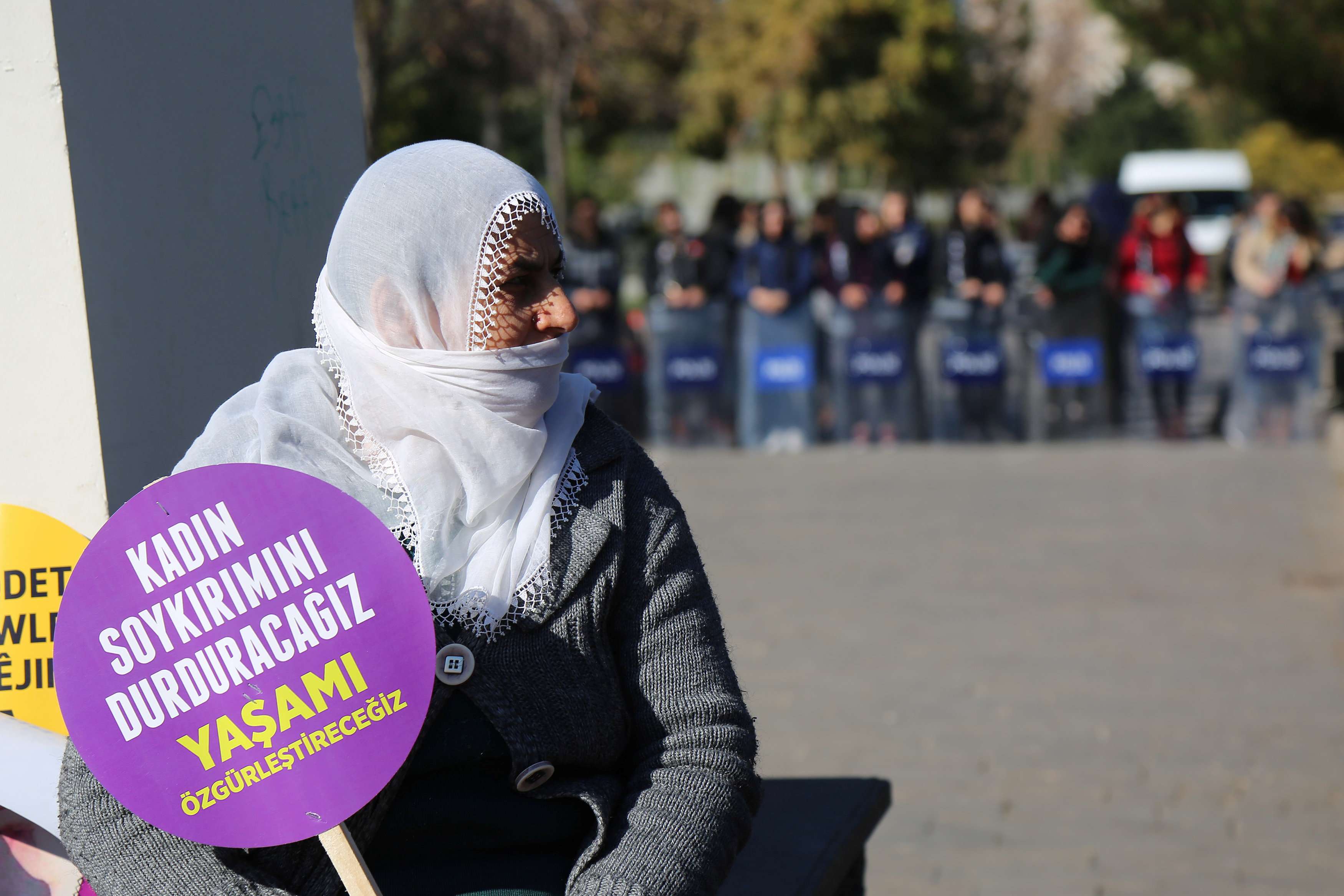 A Turkish demonstrator holds a placard reading "We will stop massacres against women."
