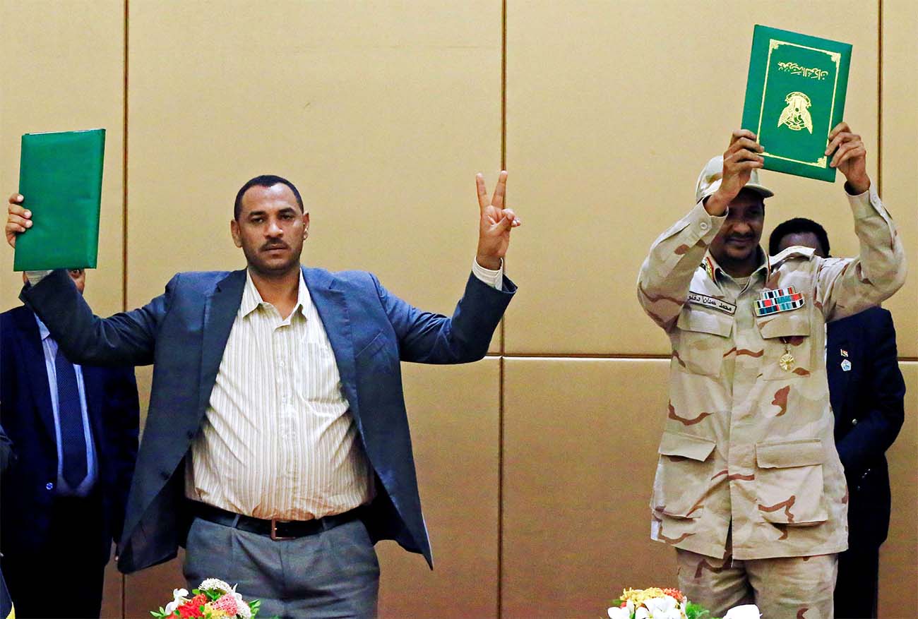Deputy Head of Sudanese Transitional Military Council, Mohamed Hamdan Dagalo and Sudan's opposition alliance coalition's leader Ahmad al-Rabiah hold up signed copies of the constitutional declaration during a signing ceremony in Khartoum