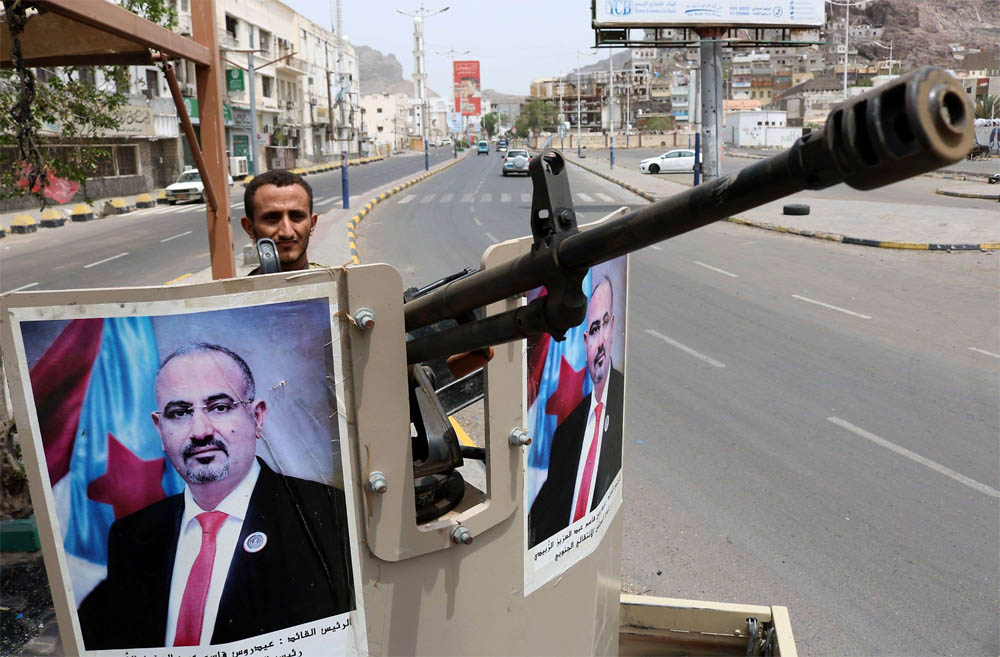 جندي من المجلس الانتقالي يرفع صورة زعيم المجلس عيدروس الزبيدي