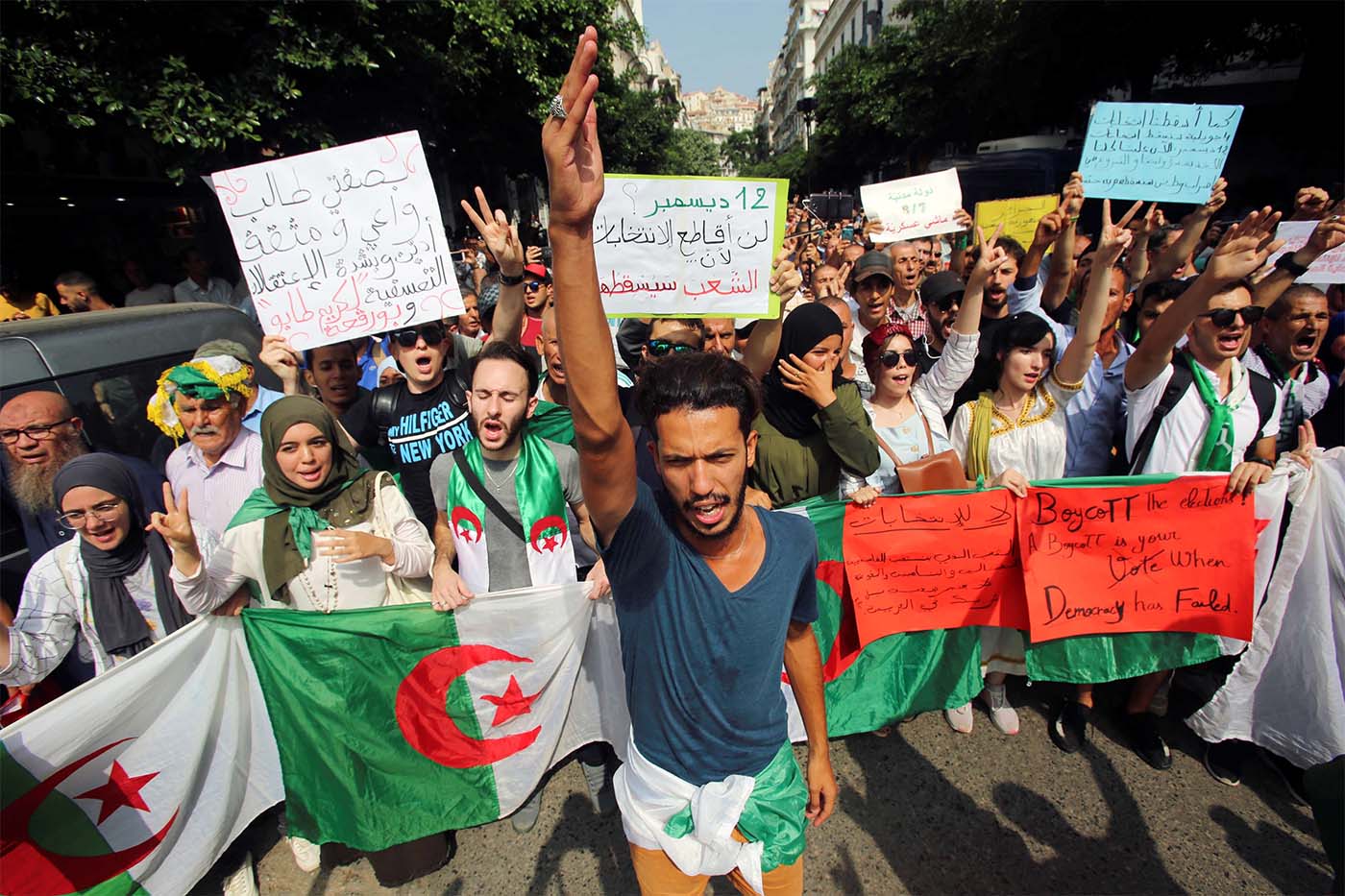 Demonstrators carry flags and banners during a protest rejecting Algerian election announcement for December