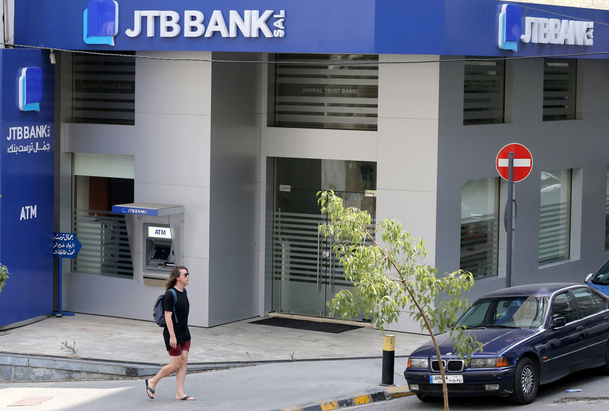 A pedestrian walks past Jammal Trust Bank (JTB) branch in Ashrafieh, Lebanon