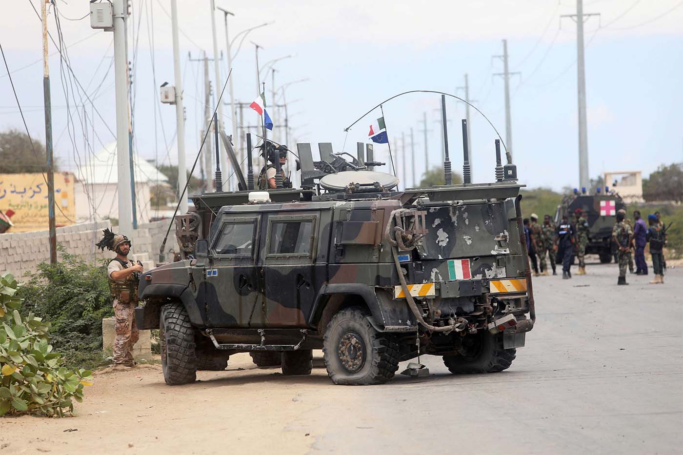 Italian security forces are seen near armoured vehicles at the scene of an attack on an Italian military convoy in Mogadishu