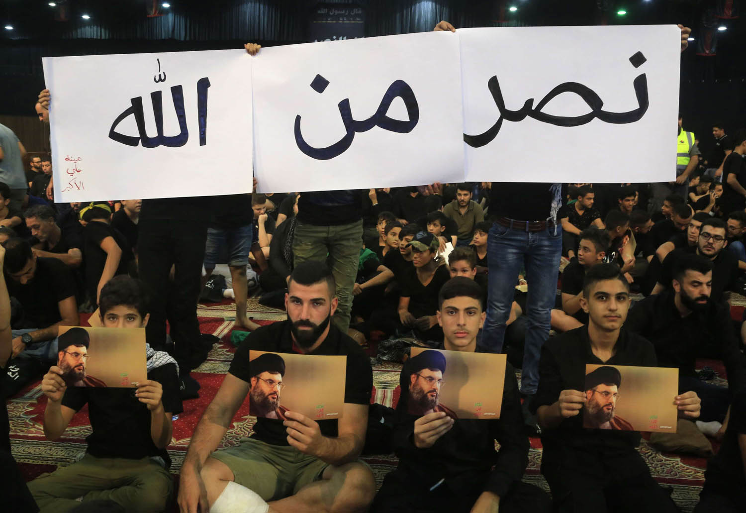ناشطون من حزب الله يرفعون صورة زعيمه حسن نصرالله