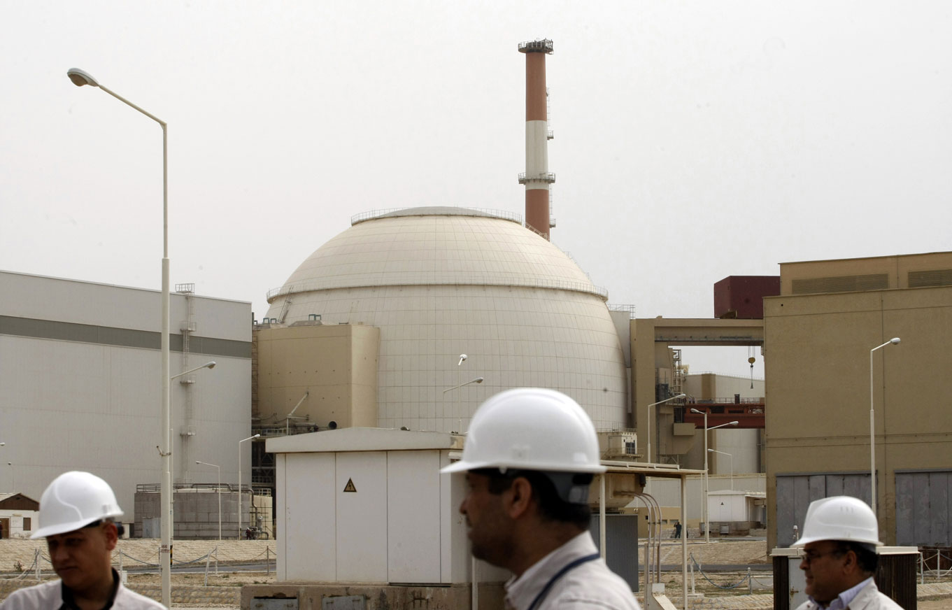 Iranian technicians walk outside the building housing the reactor of Bushehr nuclear power plant