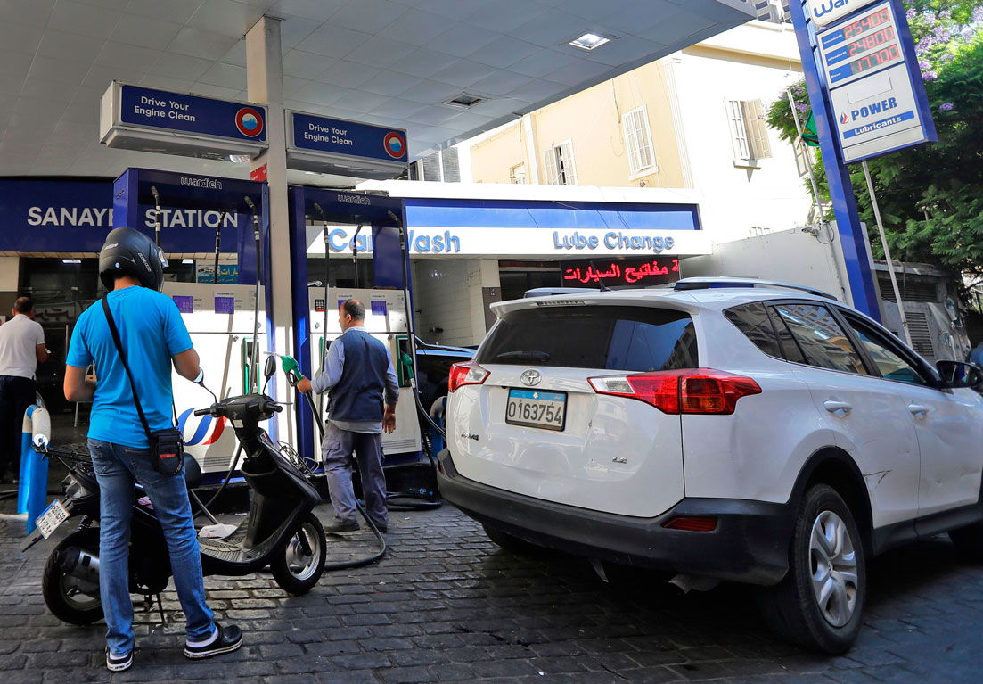 Drivers fill up at a petrol station in the Lebanese capital Beirut on September 27