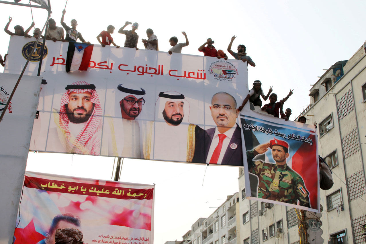 Supporters of Yemen's STC stand on a billboard during a rally