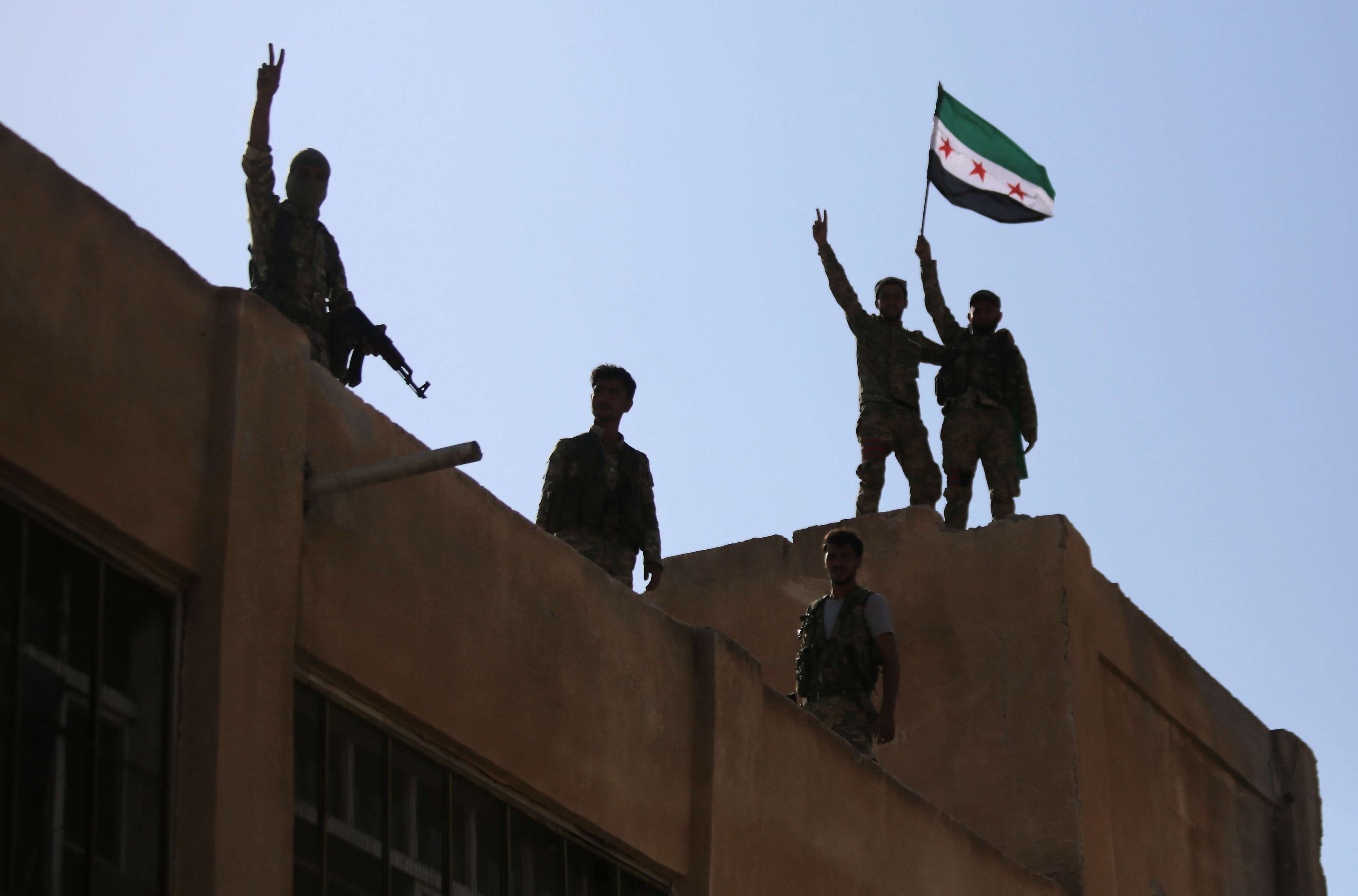 جنود سوريون يرفعون العلم داخل مدينة منبج رغم حشد تركي غفير