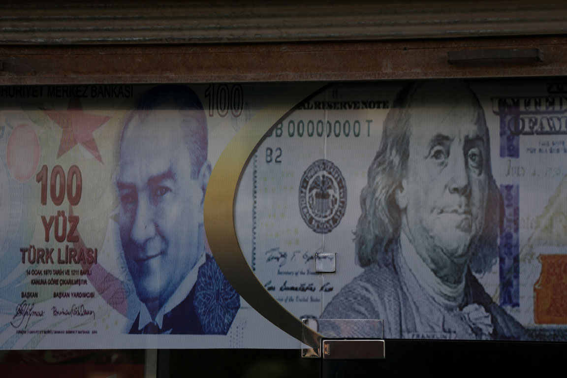 Posters of the US dollar and Turkish lira are seen on a currency exchange shop in the city of Azaz, Syria