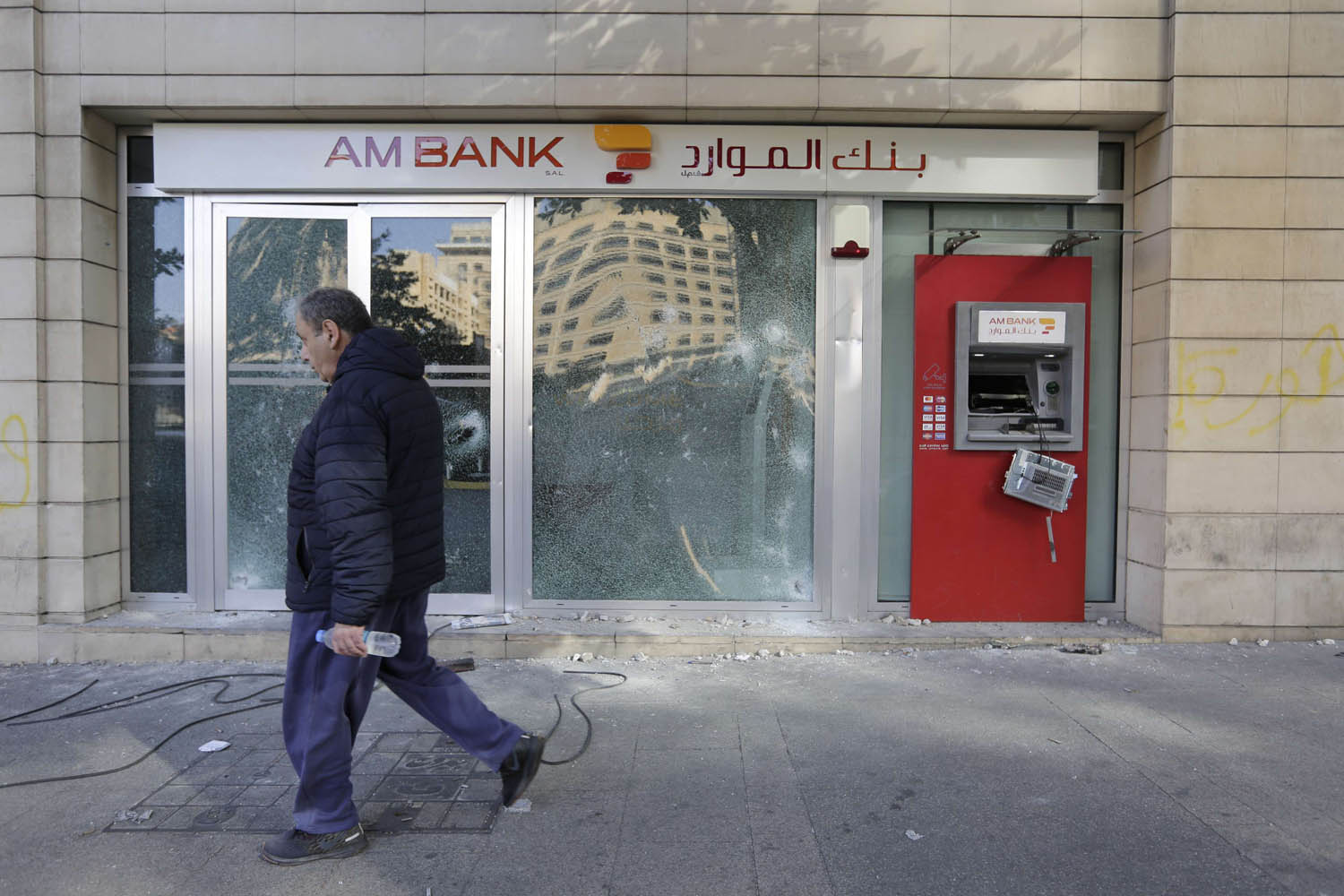 لبناني يمر بجانب واجهة بنك محطمة وسط بيروت