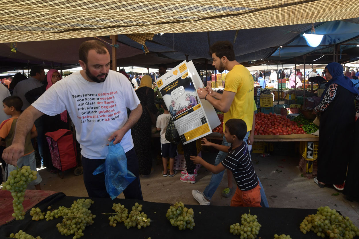 A young Tunisian from Aich Tounsi distributes campaign leaflets in the Chabaou market in Manouba