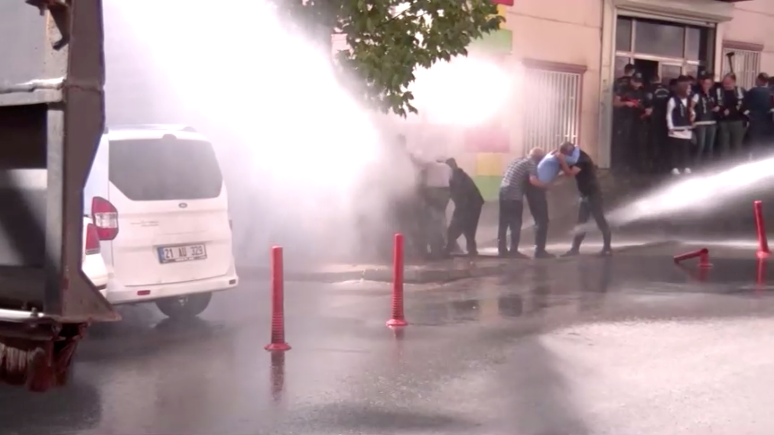 Kurds protesting Turkey's Syria operation are hit by water sprayed from a water cannon in Diyarbakir