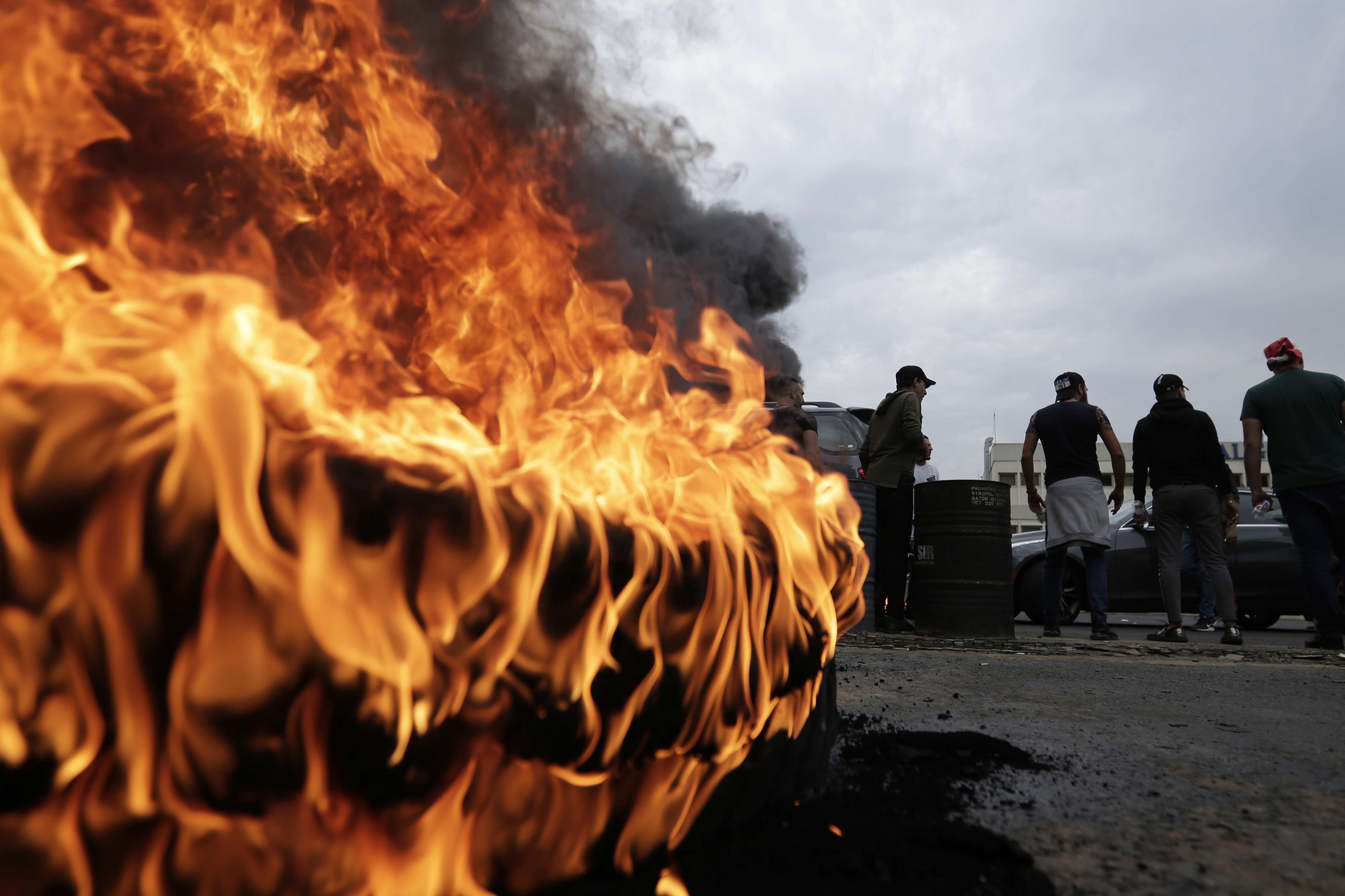 Anti-government protesters set fire to tires blocking a highway that link the Capital Beirut to north Lebanon
