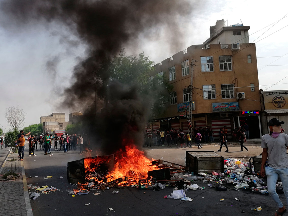 Anti-government protesters set fire and block roads in Baghdad
