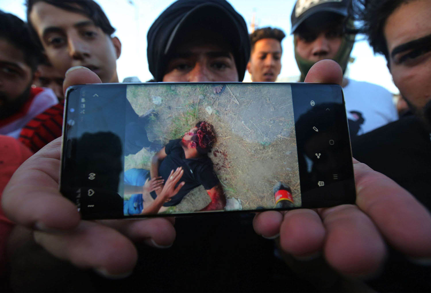 محتجون عراقيون يعرضون صورة لواحد من ضحايا القنص في الاحتجاجات في بغداد