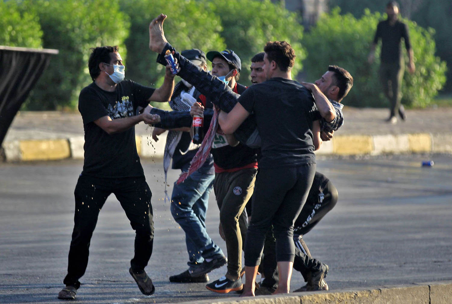 متظاهرون عراقيون يحملون زميلا مصابا في بغداد