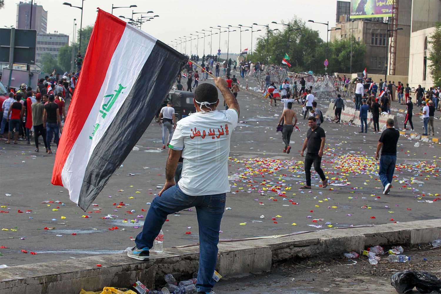 An Iraqi man waves his national flag during demonstrations in central Baghdad against their government 