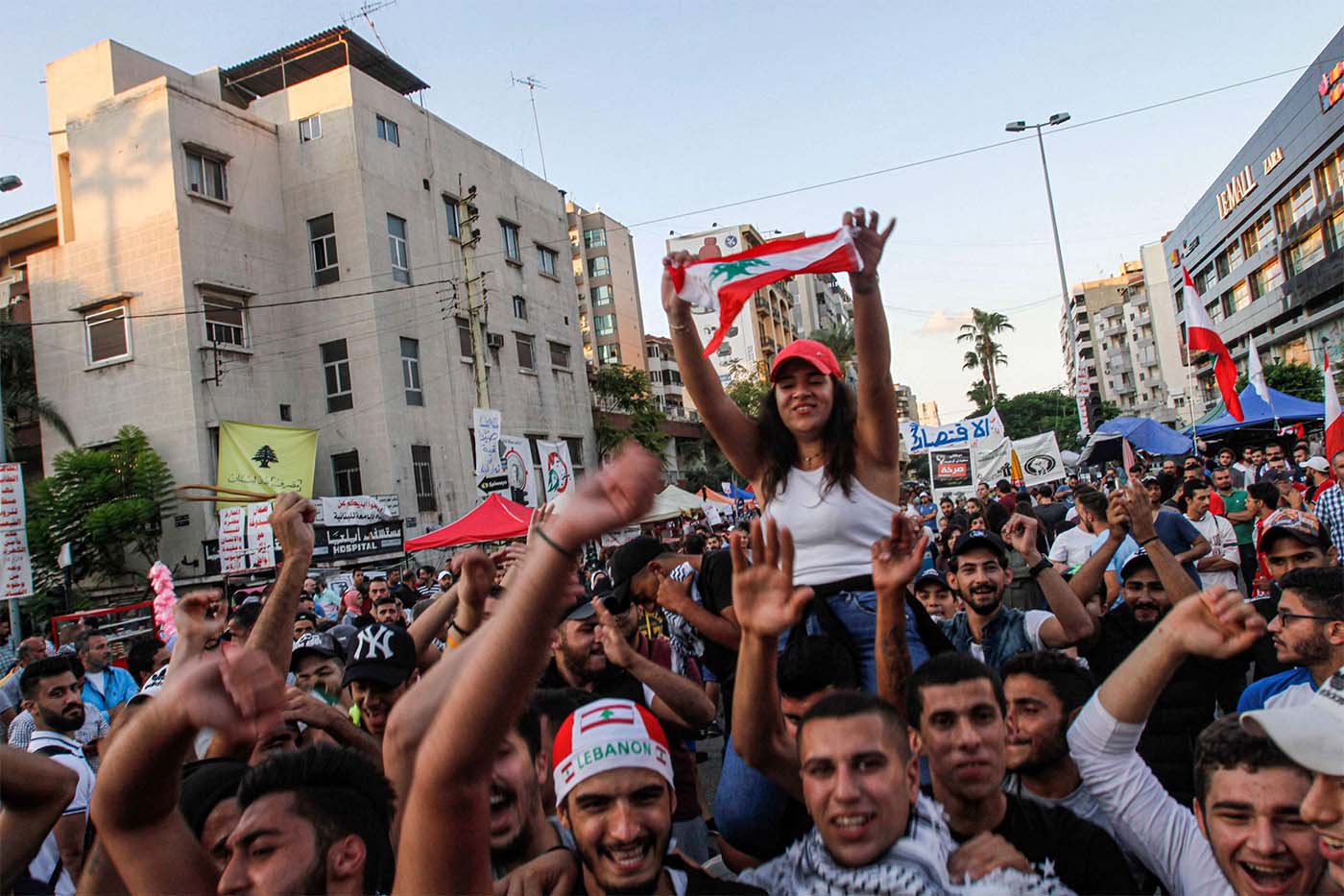 Lebanese anti-government protesters celebrate the resignation of Prime Minister Saad Hariri in Sidon