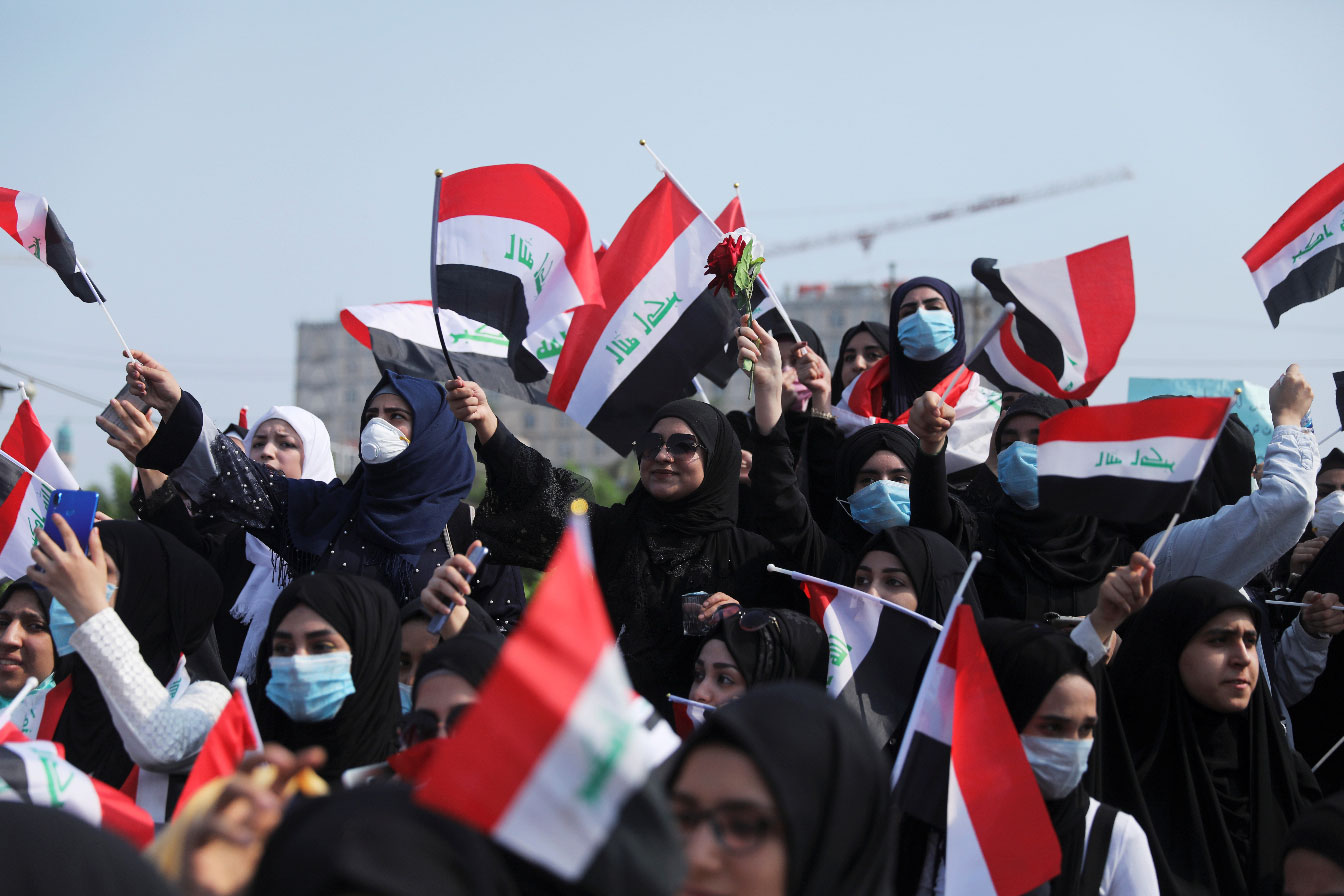 Universities students hold the Iraqi flag as they take part in a protest over corruption, lack of jobs, and poor services