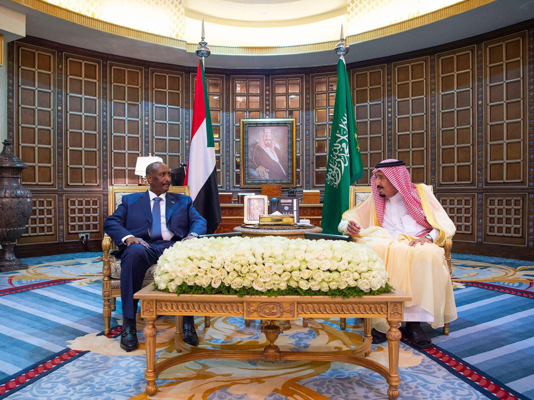 Saudi King Salman bin Abdulaziz Al Saud (L) speaks with Leader of the Sovereignty Council of Sudan Abdel Fattah al-Burhan