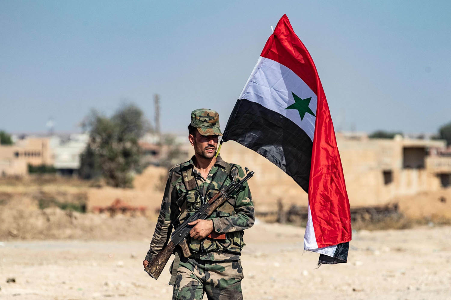 جندي سوري يرفع علم بلاده في راس العين بعد عودة الجيش لمناطق الأكراد