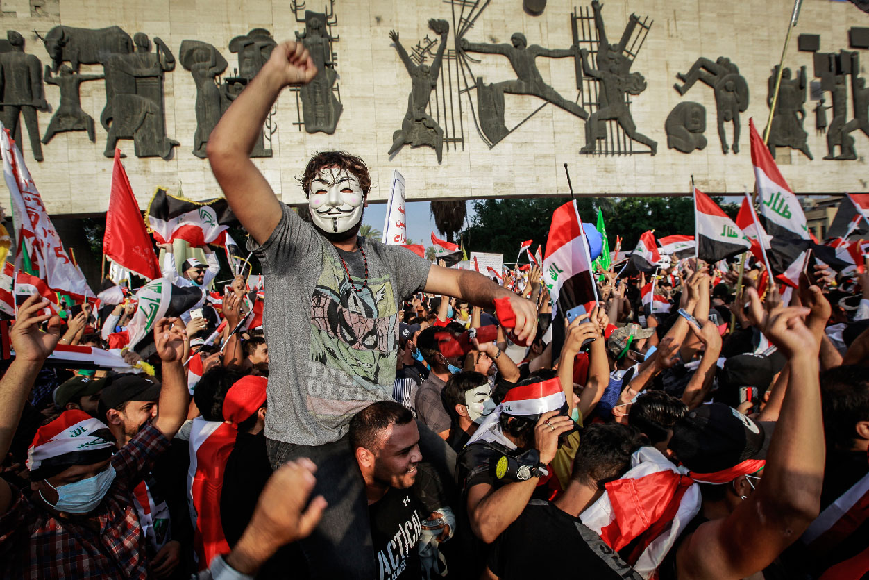 Iraqi people wave flags and shout slogans during an anti-government demonstration at Tahrir Square, Baghdad