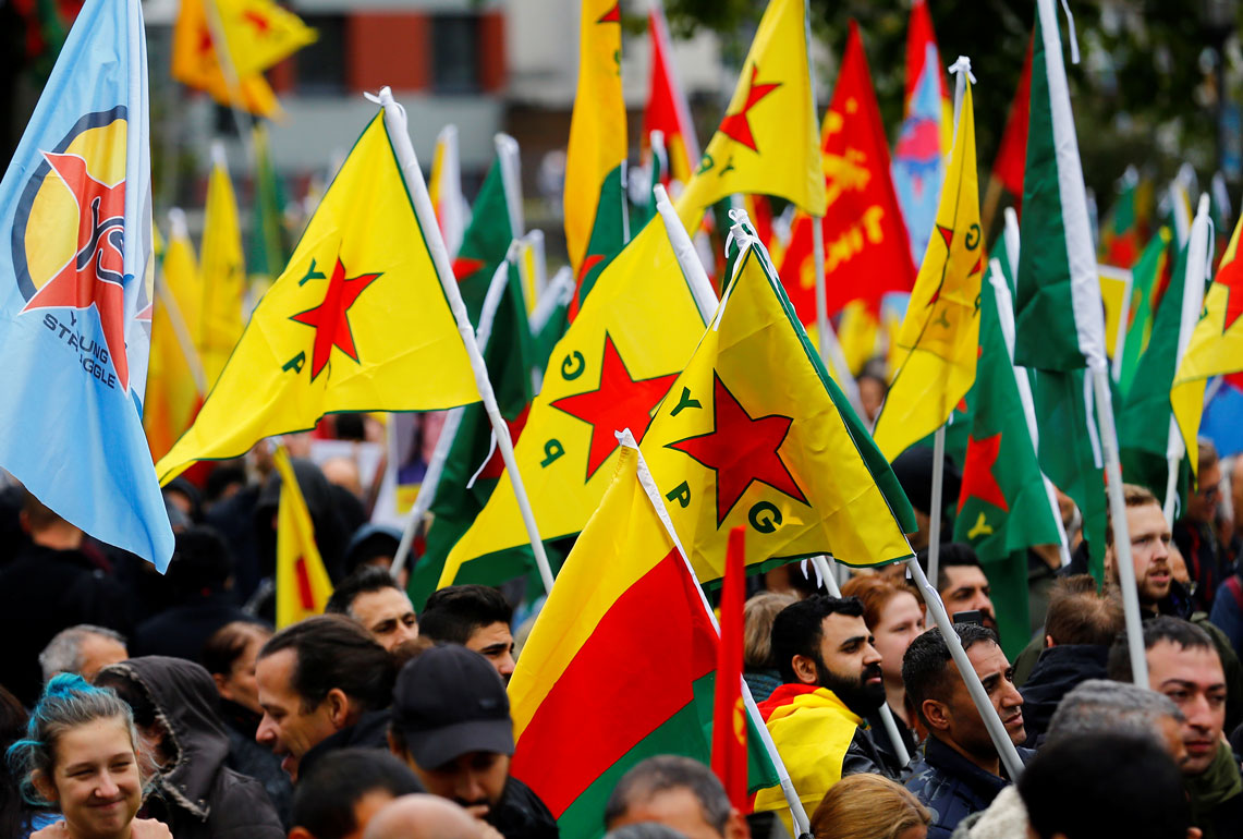 Pro-Kurdish demonstrators wave flags of the Kurdish YPG militia in Cologne, Germany