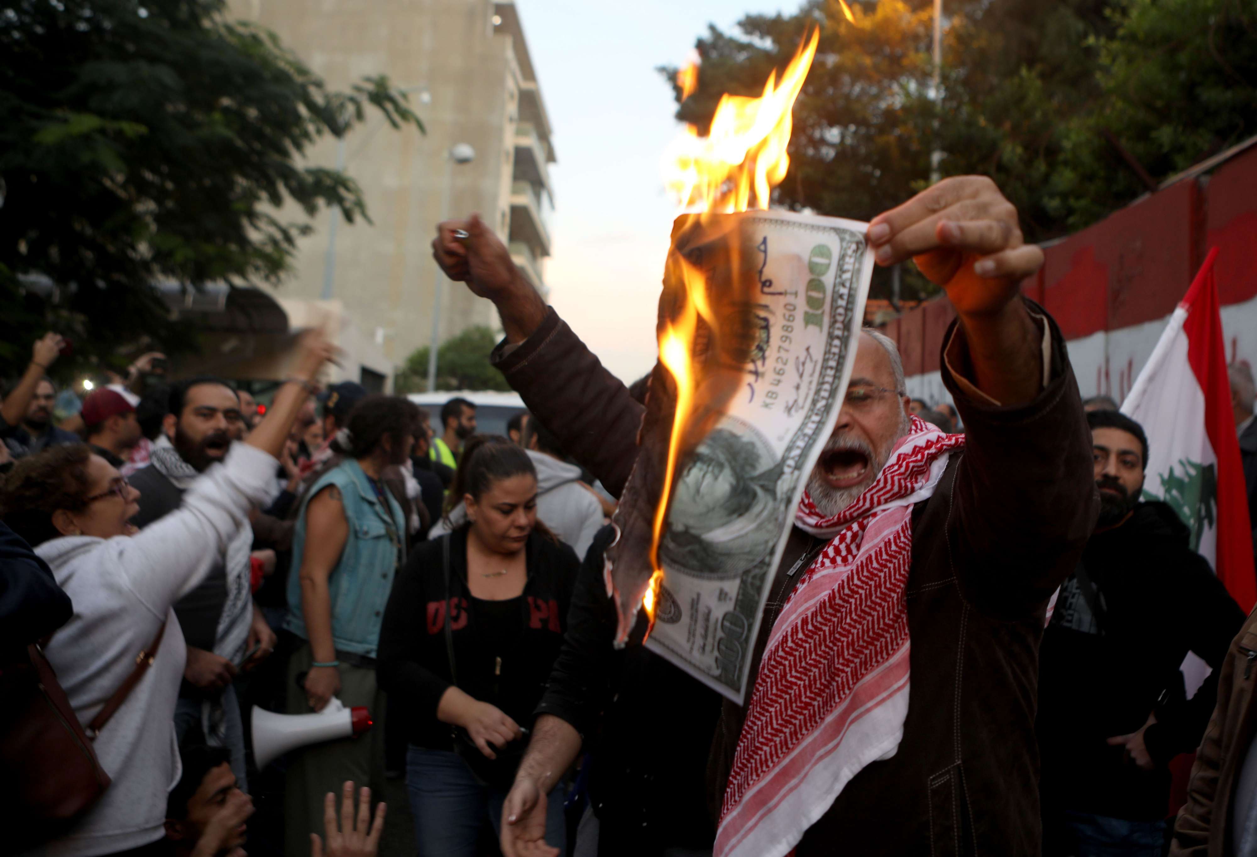 متظاهر لبناني يشعل ورقة بقيمة 100 دولار