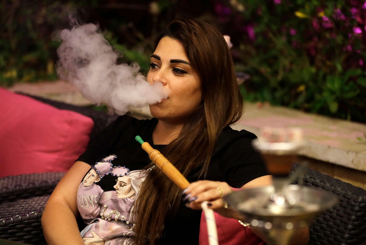 شابة تدخن الشيشة في أحد مقاهي لبنان