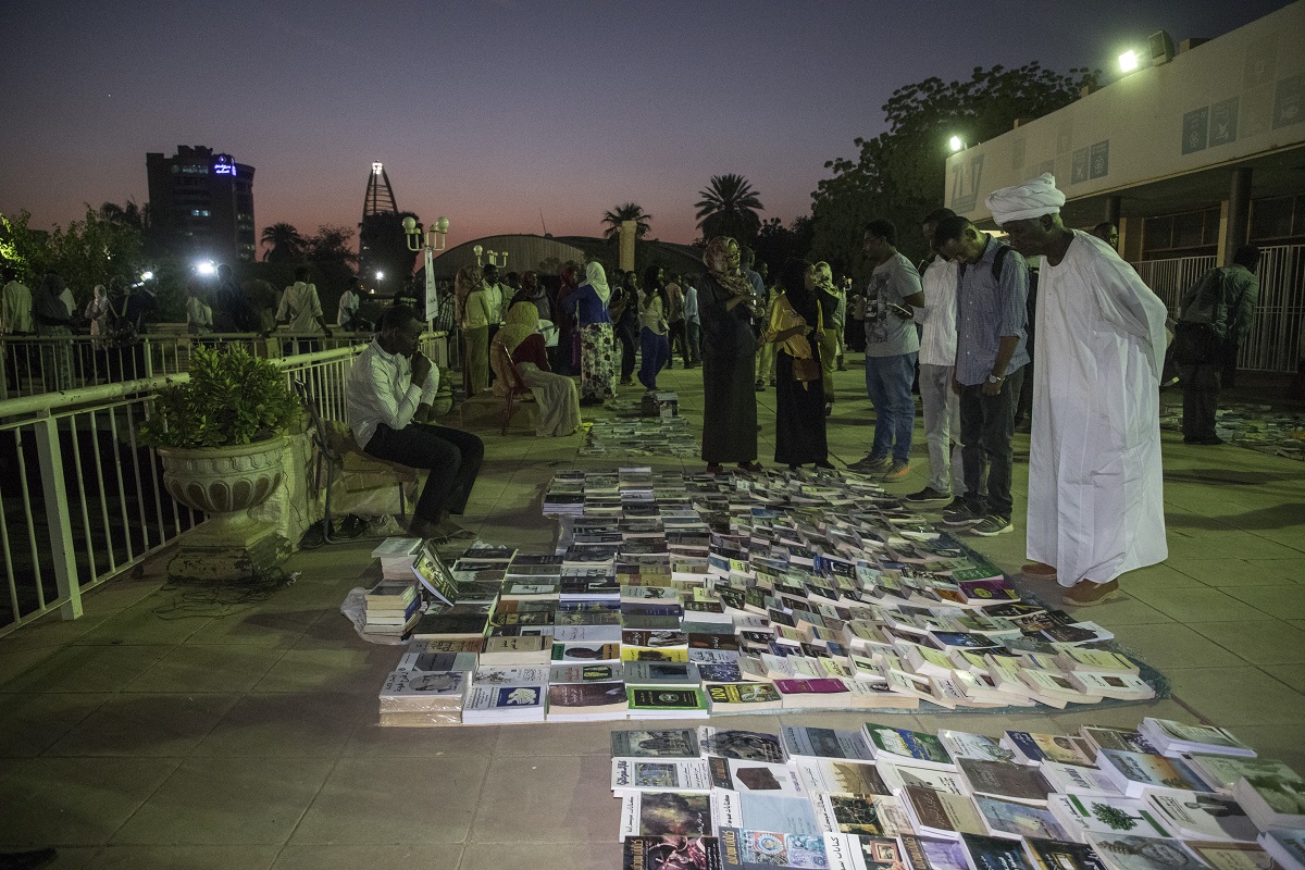 سودانيون يتجمعون حول كتب مفروشة على الأرض في معرض "مفروش"
