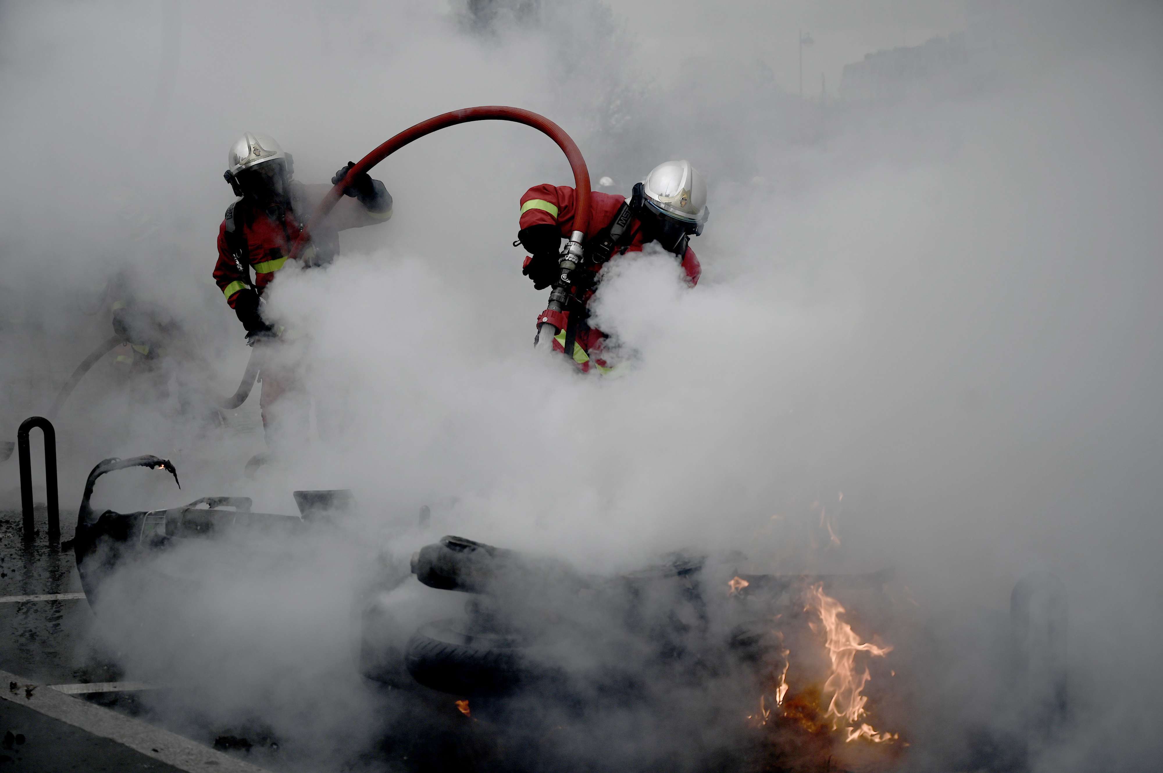 عمليات إطفاء لحريق أحدثه المتظاهرون في أحد شوارع باريس