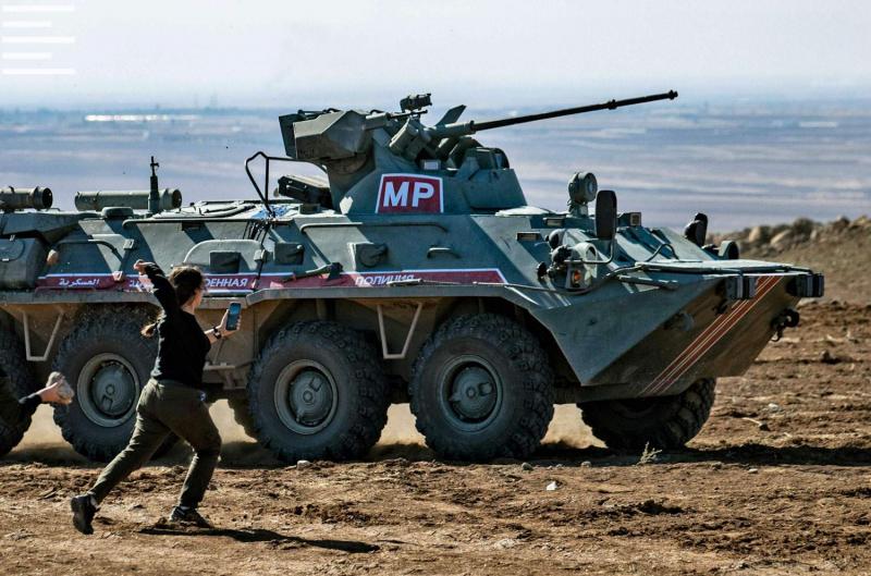 Kurdish demonstrators hurl rocks at a Russian military vehicle on November 8, 2019, during a joint Turkish-Russian patrol