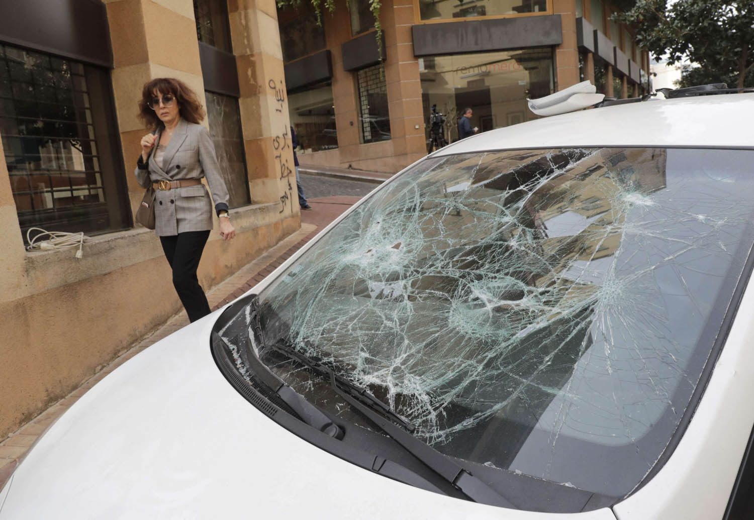 سيارة محطمة النوافذ وسط بيروت بعد اشتباكات بين انصار حزب الله وأمل والمحتجين