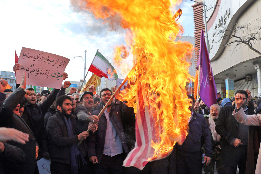 Iranians burn a US flag during a counter-protest in support of Iran's government
