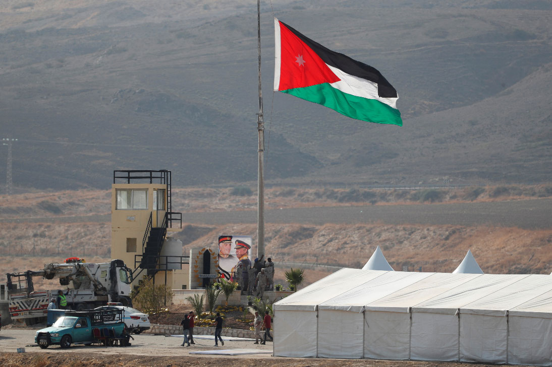A Jordanian national flag is lifted near a tent at the "Island of Peace" in Baqura