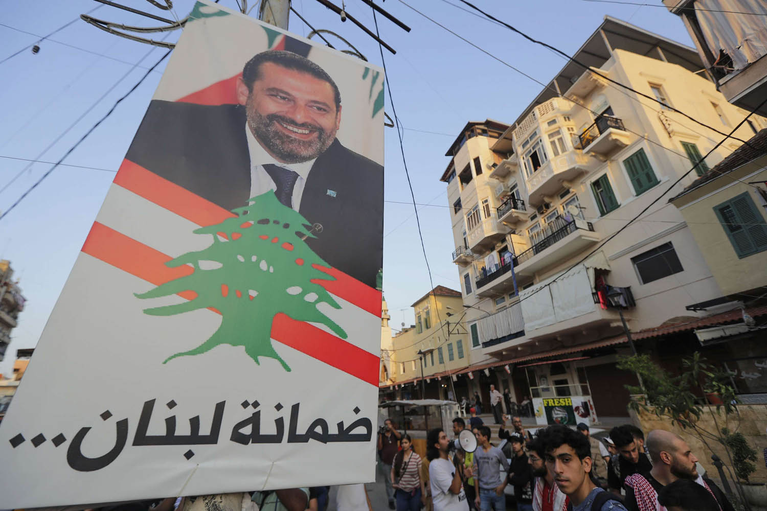 يتجمهرون في طرابلس لنزع صورة سعد الحريري من ساحة عامة