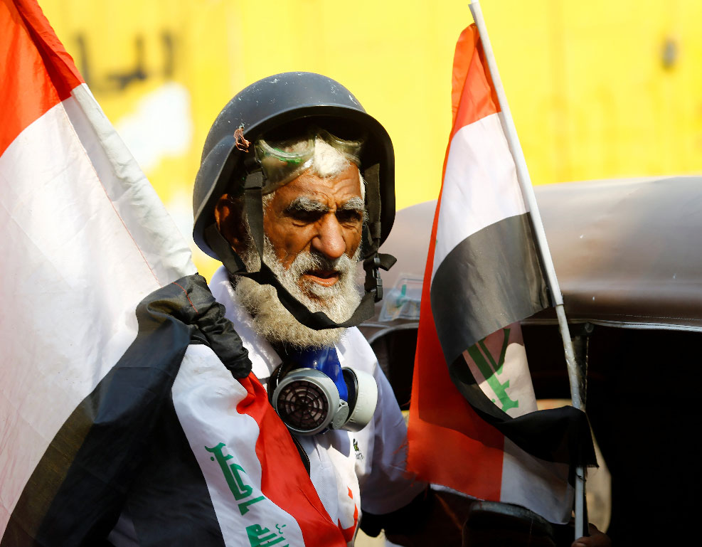 A demonstrator holds the Iraqi flag during the ongoing anti-government protests in Baghdad