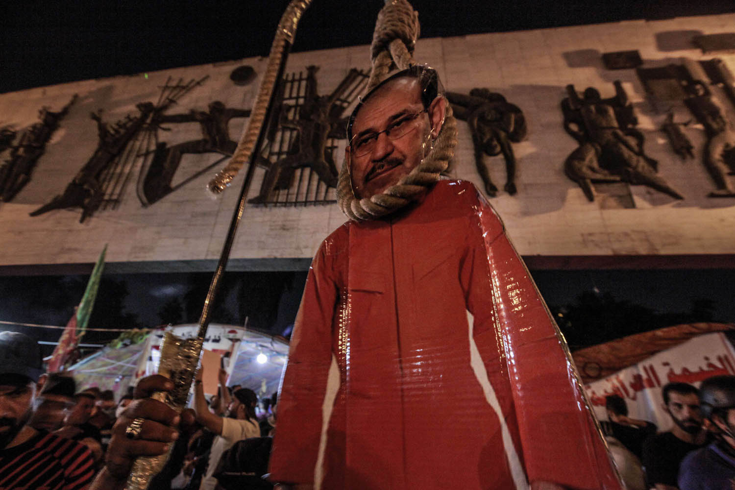 عراقيون يعلقون دمية لرئيس الوزراء السابق نوري المالكي في ساحة التحرير
