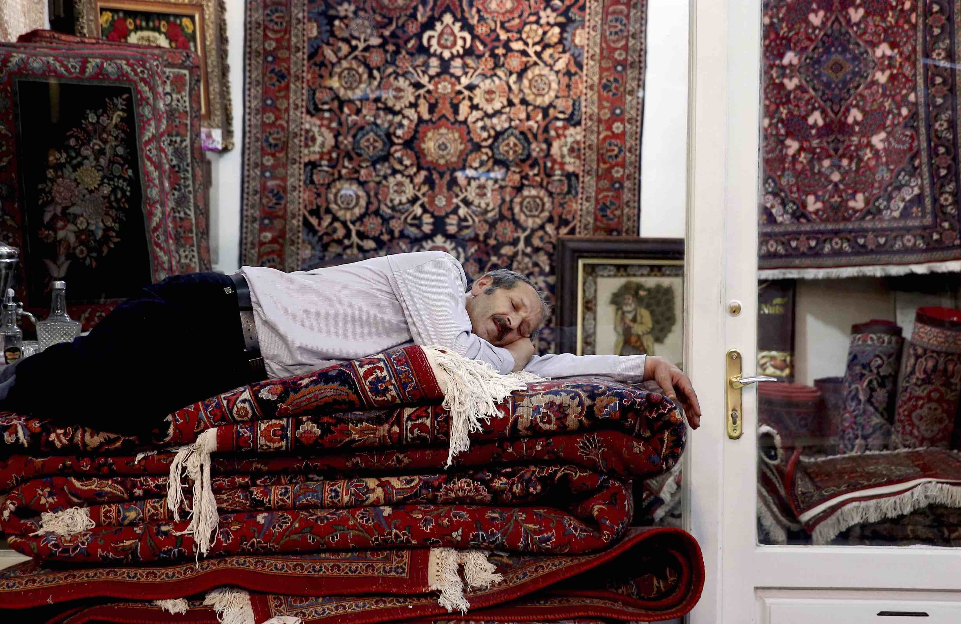 An Iranian carpet seller takes a nap in the old Bazaar in Tehran