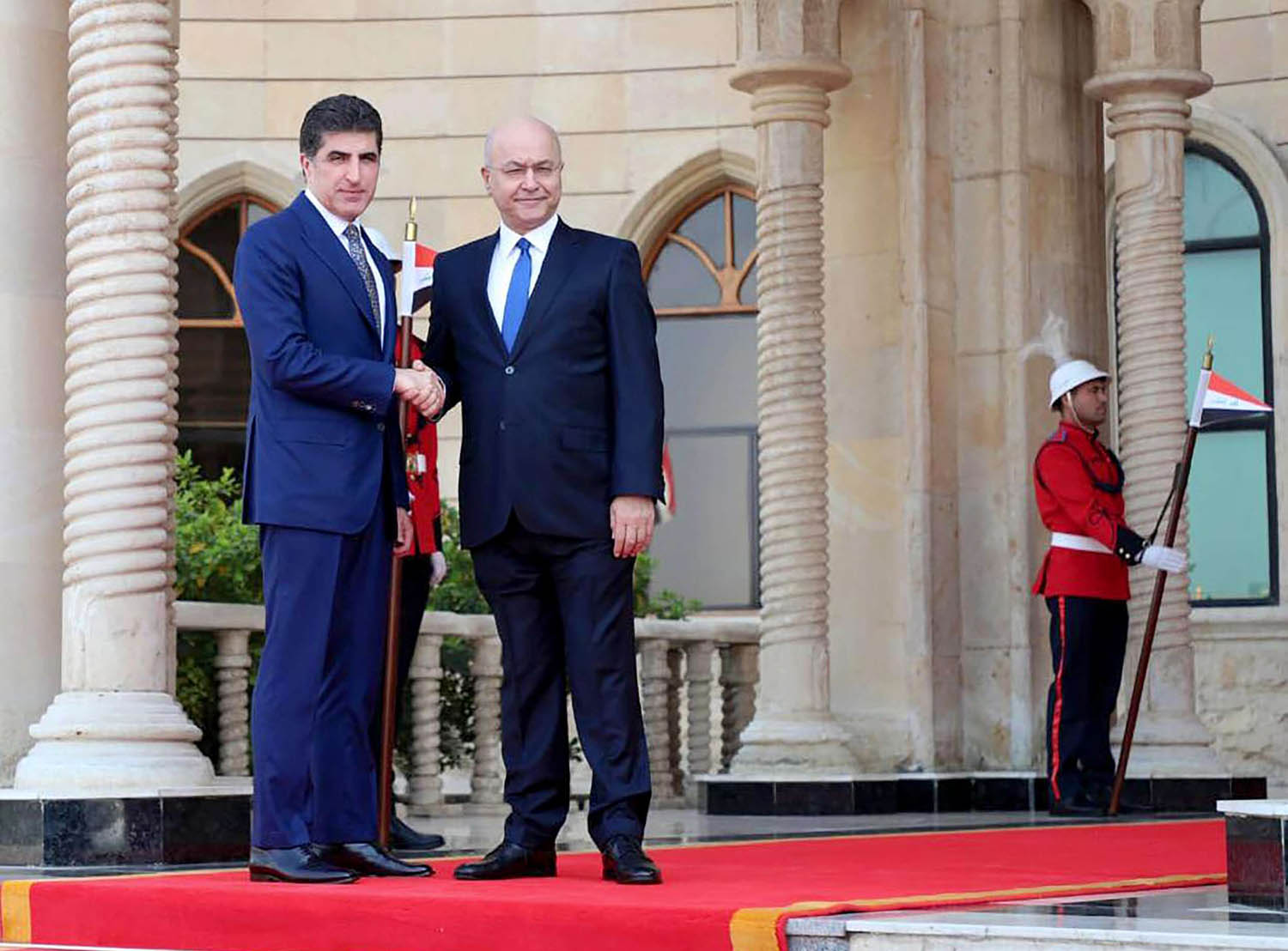 الرئيس العراقي برهم صالح يصافح رئيس اقليم كردستان نيجيرفان بارزاني