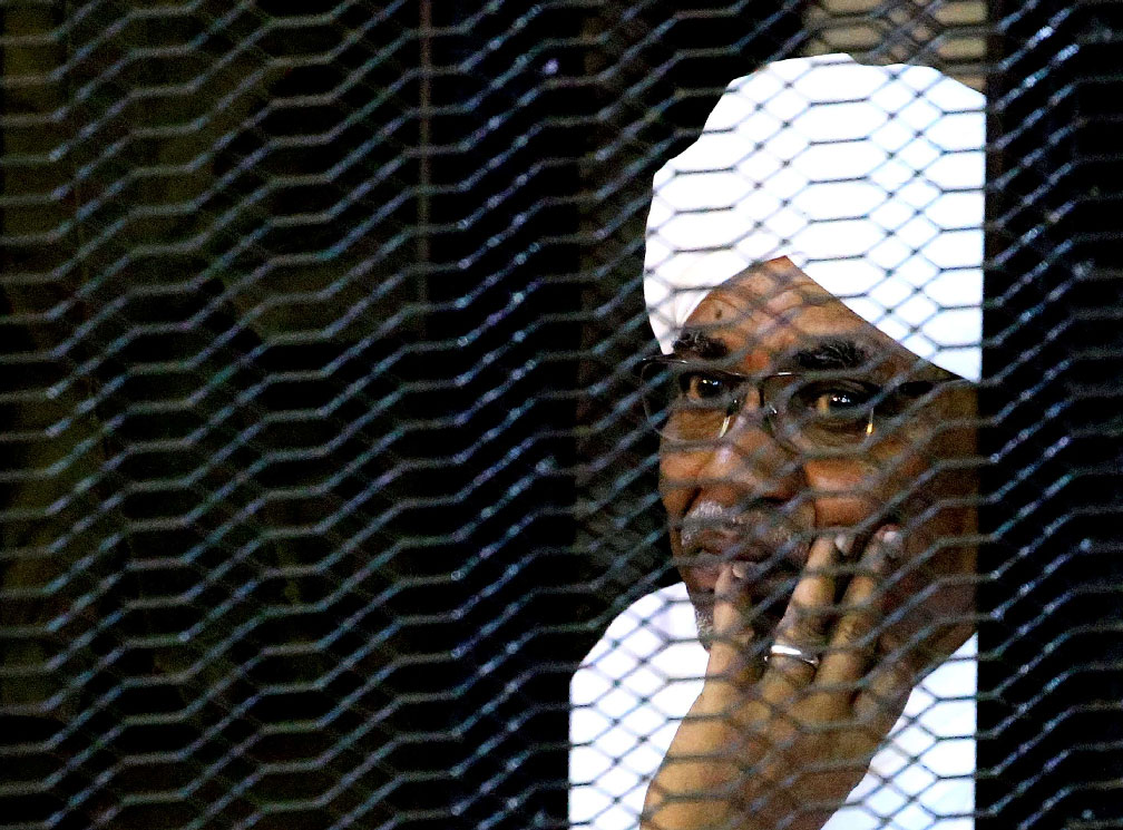 Sudanese former president Omar Hassan al-Bashir sits inside a cage as he faces corruption charges in a court in Khartoum