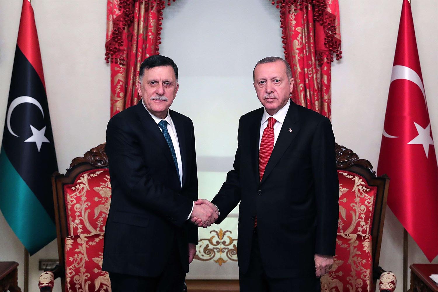 Turkish President Recep Tayyip Erdogan (R) shaking hands with Fayez al-Sarraj (L)