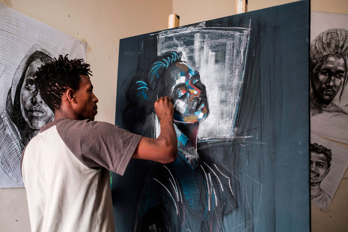 Eritrean artist Nebay Abraha, 23, is pictured while working on a painting in his room and studio in Addis Ababa