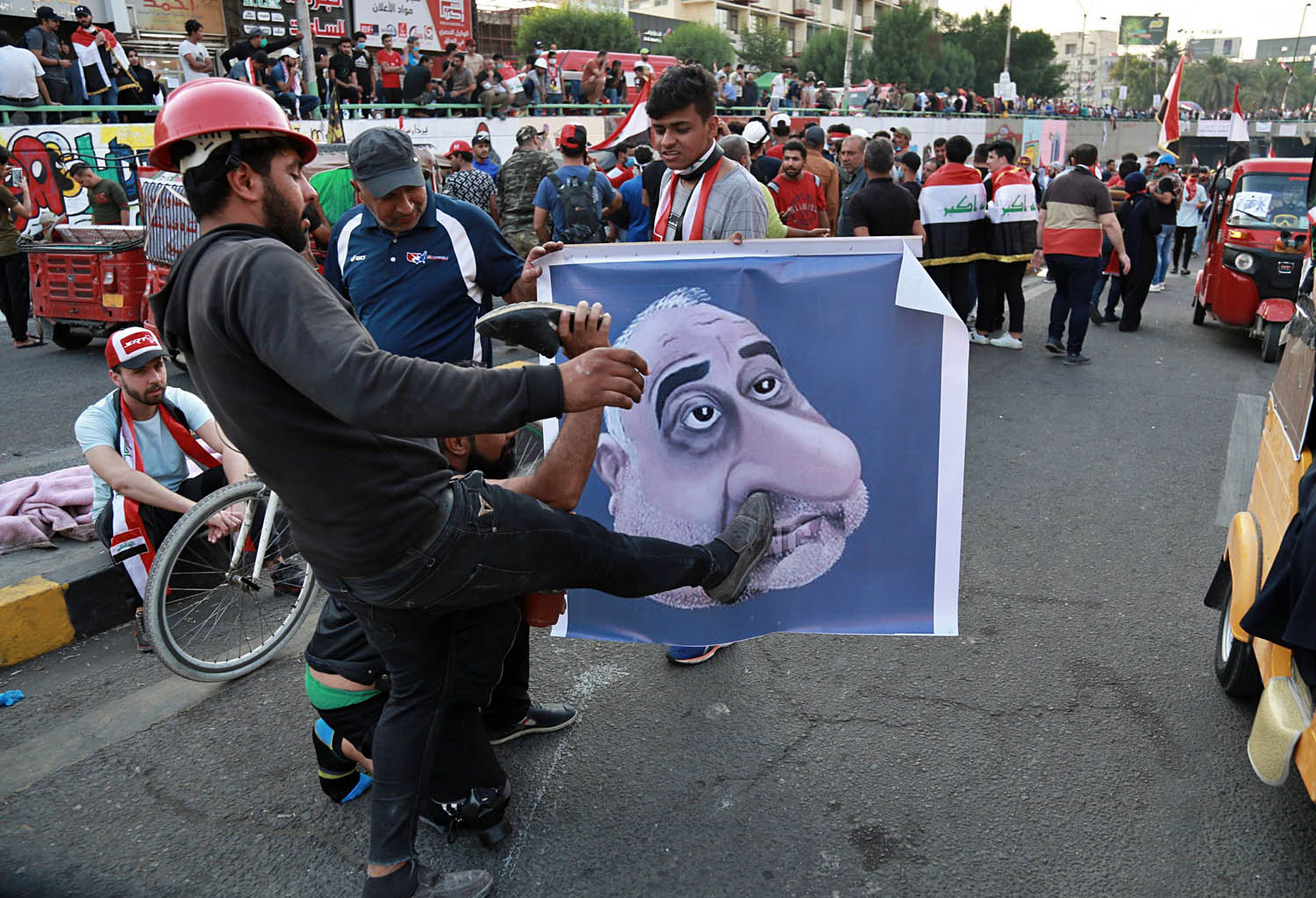 عراقيون يضربون تخطيطا لرئيس الوزراء العراقي المستقيل عادل عبدالمهدي